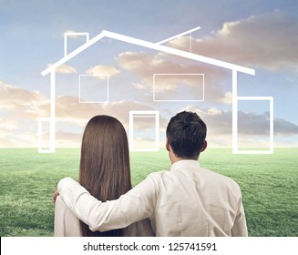 Couple, From The Back, On A Large Lawn Watching A House Drawn On A Large Lawn