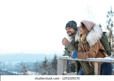 Couple with backpacks enjoying mountain view during winter vacation. Space for text - Powered by Shutterstock