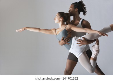 Couple Of Ballet Dancers Posing Over Gray Background