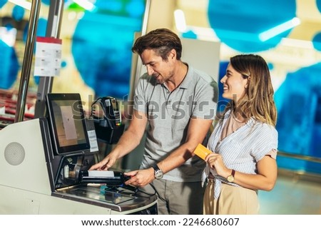 Couple with bank card buying food at grocery store or supermarket self-checkout
