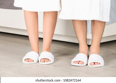 Couple in bathing slippers at home