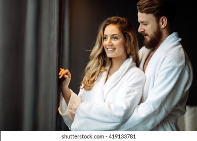 Couple In Bathrobes Enjoying Honeymoon In Spa Resort