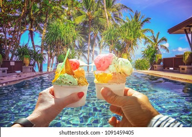 Couple with beautiful bright  sweet Italian ice-cream with different flavors  in the hands  . Background of  panoramic view of tropical beach with coconut palm trees. Koh Samui, Thailand - Powered by Shutterstock