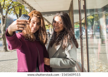 Similar – Männerhände fotografieren zwei glückliche Frauen im Freien.