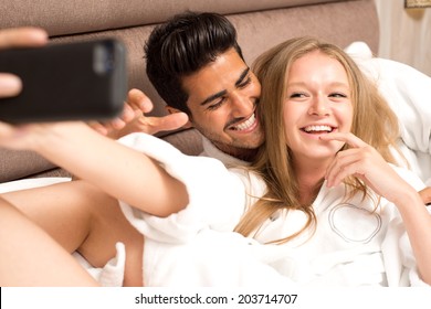 Couple in bed taking a selfie and having fun 