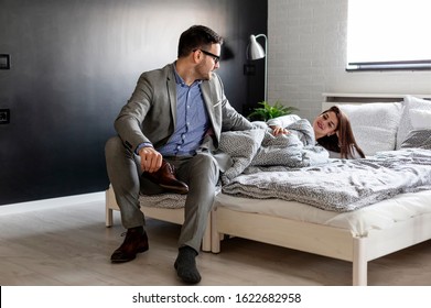 Couple In Bedroom And He Prepare For Work At Suit And She Is In Pijama On Bed Wake Up