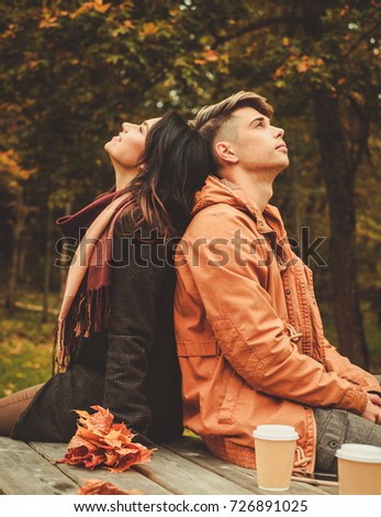 Couple behind wooden table in autumn park