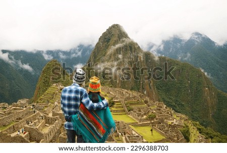 Couple being impressed with the incredible view of Machu Picchu ancient Inca citadel, UNESCO world heritage site in Cusco Region, Peru, South America
