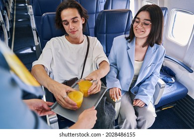 Couple Being Served A Beverage In The First Class Cabin