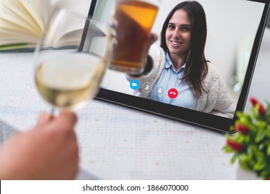 Couple of best friends drinking and toasting online with wine and beer on a video call during the quarantine lockdown. Stay safe at home lifestyle concept. - Powered by Shutterstock