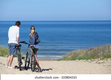 Couple with bicycles looking at the ocean - Powered by Shutterstock