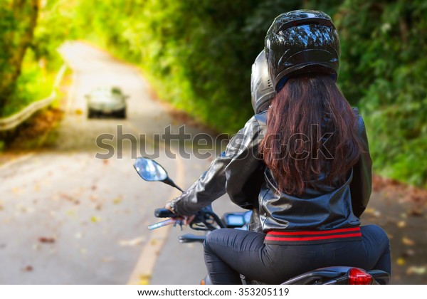couple biker\
riding motorcycle in asphalt\
road