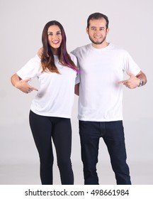 Couple With Blank White Shirt, Front . Pointing To Your Artwork.