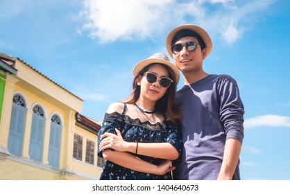 A Couple Of Blogger Tourists From Southeast Asia Visit Phuket In Thailand Are Captured In The Old Town During Write Travel Reviews With Sunlight And Temple Background In Travel Concept