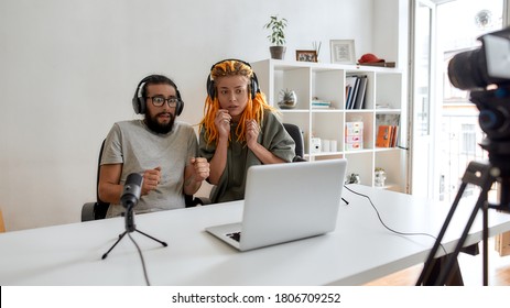 Couple Of Bloggers, Young Man And Woman Looking Scared While Watching Something On Laptop, Recording Reaction Video Blog Or Vlog