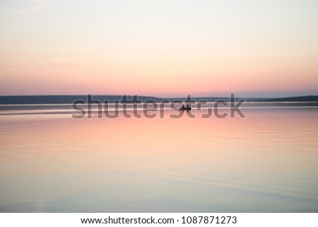 Couple in a boat in a lake or pond or river in a sunset calm water no wind summer minimalism silhouette people beautiful meditation tourism outdoor meditation life happiness