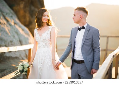 The couple, the bride and groom holding hands in the mountains - Shutterstock ID 2253913557