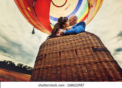 Couple Bride And Groom Kissing In Basket Of Balloon