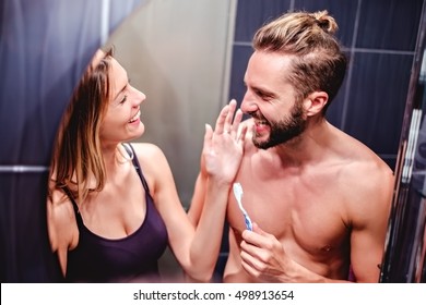 Couple brushing teeth and having fun in the bathroom - Powered by Shutterstock