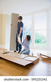 Couple Building Furniture In New Home