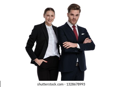 couple in business suits standing together with arms crossed and hand in pocket on white background - Shutterstock ID 1328678993