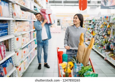 Couple Buying A Lot Of Diapers In Supermarket