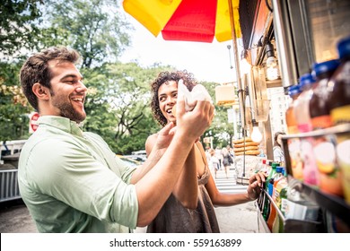 Couple buying a hot dog in a kiosk in New York
