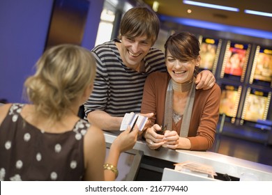 A Couple Buying Movie Tickets At The Box Office.