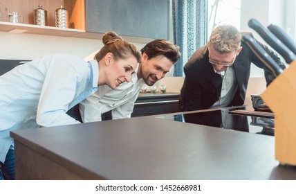 Couple Buying New Kitchen In The Store Looking At Some Details