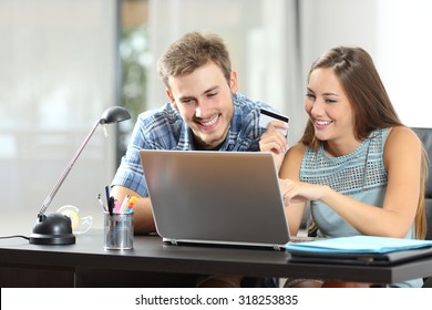 Couple Buying Online Together With A Laptop On A Desktop At Home