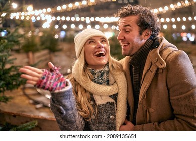 Couple Buying Perfect Christmas Tree At Snowy Night