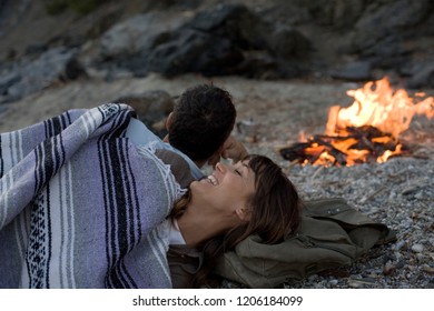 Couple Camping On The Beach By The Fire