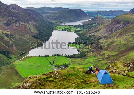 Couple campiong on top of Haystacks peak overlooking Buttermere lake in Lake District.Cumbria. UK