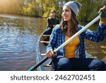 Couple, canoe and lake rowing for nature holiday or exploring outdoor, environment or journey. Man, woman and happy or travel weekend on island river at camp for vacation in Colorado, calm or forest