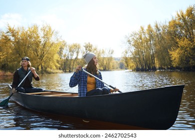 Couple, canoe and lake rowing in wood for exploring nature or teamwork for healthy morning, travel or journey. Man, woman and camp site in Colorado or forest weekend for autumn trip, weekend or calm - Powered by Shutterstock