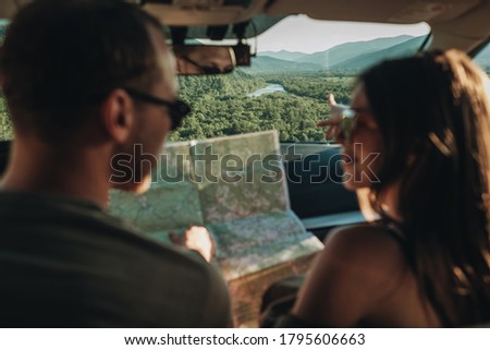 Couple in Car Going on Roadtrip, Man and Woman Using Map