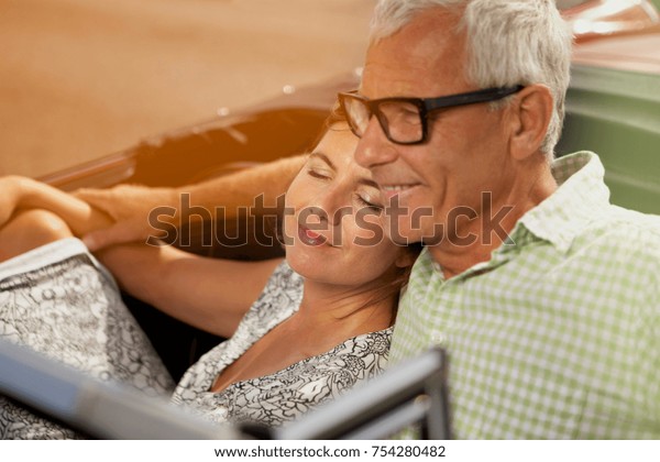 Couple in car, her head on\
shoulder