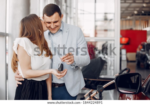 Couple in a car salon. Family buying the car.\
Elegant woman with her\
husband.