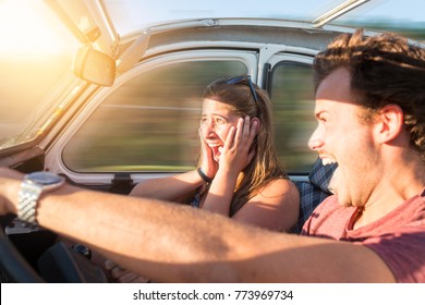 Couple in a car at sunset, with male driving fast and girl scared, screaming and praying.