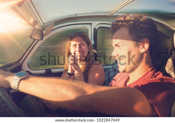 Couple in a car at sunset, with
male driving fast and girl scared, screaming and
praying.