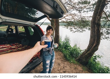 Couple Car Travel. Woman Giving Cup Of Coffee To Man. First Person Point Of View