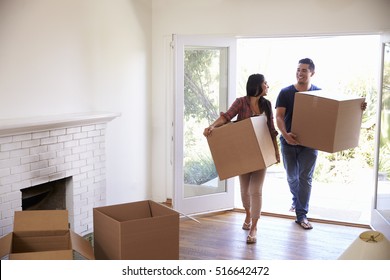 Couple Carrying Boxes Into New Home On Moving Day - Shutterstock ID 516642472