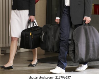 Couple Carrying Their Luggage In A Hotel.