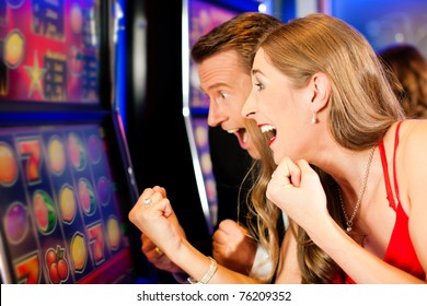 Couple in Casino on a slot machine - Shutterstock ID 76209352