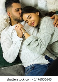 couple casual stylish lovers are laying in the bed and cuddling. the oriental guy is kissing the girl in the hair and holding the hand. lifestyle romantic concept - Shutterstock ID 1496036645