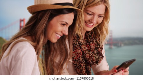 Couple of Caucasian females in San Francisco talking and reading texts together - Powered by Shutterstock