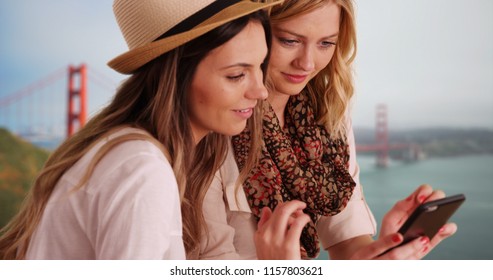 Couple of Caucasian females in San Francisco talking and reading texts together - Powered by Shutterstock