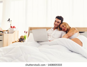 Couple caucasian lover smiling enjoy using laptop computer together on bed early morning - Powered by Shutterstock