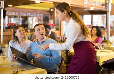 Couple of Caucasian man and woman talking about menu with waitress in restaurant. - Powered by Shutterstock