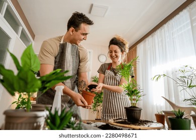 Couple caucasian man and woman wife and husband planting flowers together taking care of home plants real people domestic life family gardening concept copy space - Powered by Shutterstock